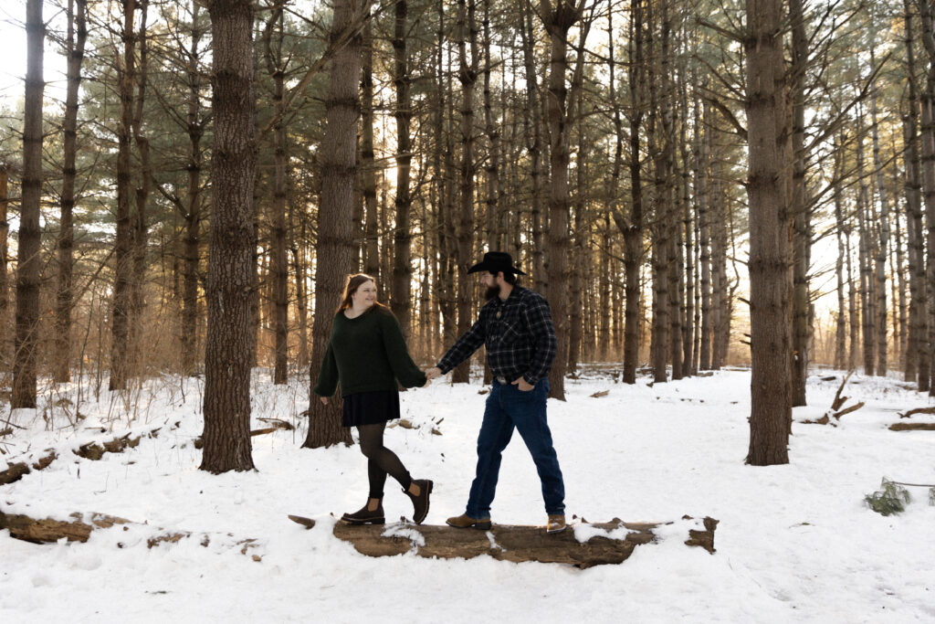 Couple poses among the pine trees in Burr Oak Conservation Area